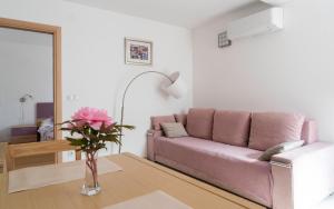 茨雷斯Apartments Lila的客厅配有粉红色的沙发和桌子
