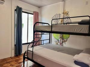 别霍港La Tribu Boutique Hostel for women的带窗户的客房内的两张双层床