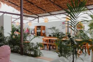 别霍港La Tribu Boutique Hostel for women的一间设有桌子和植物的餐厅