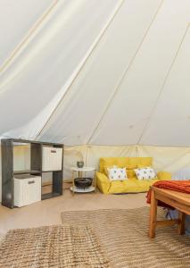 查塔努加Farm Glamp, Outdoor Shower, Pool! 15min to Chatt!的帐篷内带黄色沙发的客厅