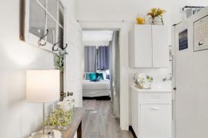 莫比尔Charming Midtown Apt - Hannon Hideaway Unit A的厨房配有白色橱柜和带台灯的桌子