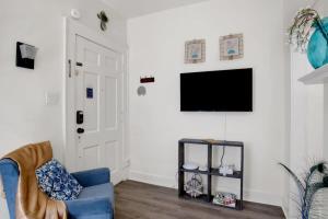 莫比尔Charming Midtown Apt - Hannon Hideaway Unit A的客厅配有蓝色的沙发和平面电视。