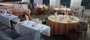 伊巴丹ED&DRE Luxuria Hotel的一组桌子上装有白色桌布