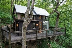 查塔努加Treetop Hideaways: The Wood Lily Treehouse的树林中的树屋,带大甲板