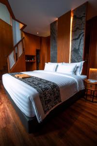 婆罗浮屠Hotel Le Temple Borobudur的卧室配有一张白色大床和木墙