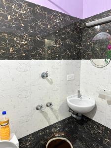 根尼亚古马里Tamizh Nest - தமிழ்க்குடில்的黑白浴室设有水槽和卫生间