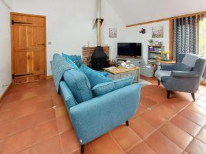 伍尔Meadow Barn的客厅配有蓝色的沙发和两把椅子