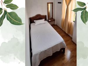卢那欢纳Killari-Hospedaje Puro Jita的卧室配有一张床,墙上挂着植物