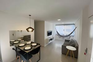 福塔莱萨Hosts BR - Apartamentos funcionais的厨房以及带桌椅的起居室。