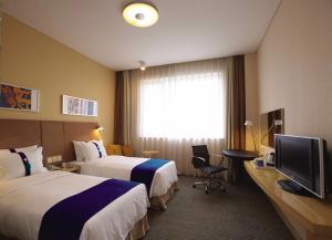 张掖张掖智选假日酒店的酒店客房设有两张床和电视。