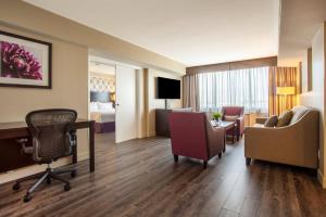 多伦多多伦多国际机场假日酒店的酒店客房设有一张桌子和椅子,还有一间卧室。