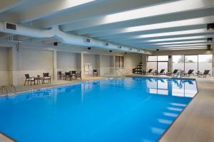 多伦多多伦多国际机场假日酒店的一个带桌椅的大型游泳池