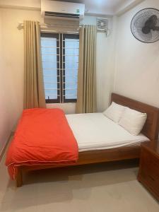 河内Phòng đơn có cửa sổ thoáng mát khép kín + Thang máy的一间卧室配有一张带红色毯子的床和窗户。