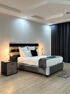 哈拉雷holiday villa的一间卧室配有一张大床和一个床头柜