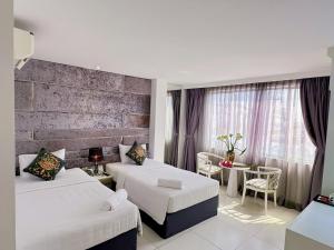 胡志明市Aodai Inn Saigon的酒店客房设有两张床和一张桌子。