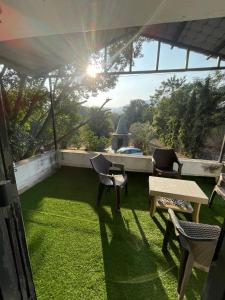 浦那OTE Dulis Den的庭院配有桌椅和草地。