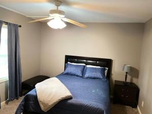 堪萨斯城The Woodland Villa的一间卧室配有一张带蓝色枕头的床和吊扇
