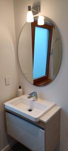 但尼丁Luxurious waterfront accommodation的浴室设有白色水槽和镜子