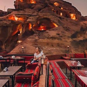 瓦迪拉姆WADI RUM STAR WARS CAMP的坐在摇滚壁前椅子上的女人