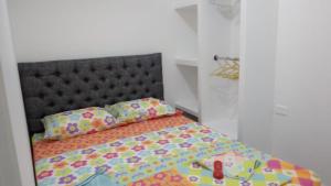巴耶杜帕尔APTO AMOBLADO CERCA A PLAZA ALFONSO LOPEZ的一间卧室配有一张带黑色床头板和枕头的床。