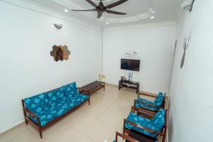 淡文GLYSM Tambun Stay "Pura Vida"的客厅配有蓝色的沙发和椅子