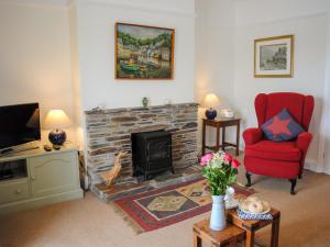 索尔科姆The Keel Row的客厅设有壁炉和红椅
