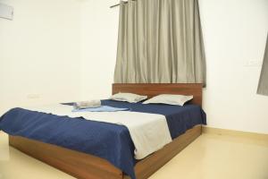 帕纳吉Sai Homestay Panaji 2 BHK and Studio Apartment的一间卧室配有蓝色和白色床单