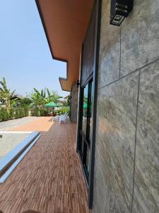 清刊Vamin Poolvilla Chiangkhan Loei วามินทร์พูลวิลล่า เชียงคาน เลย - วามินทร์ รีสอร์ท的一座带砖砌走道的建筑,毗邻庭院