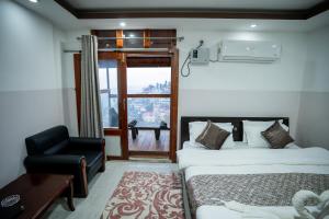 Kohīma2K HOTEL的卧室配有床、椅子和窗户。