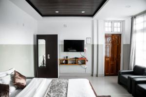 Kohīma2K HOTEL的一间卧室配有一张床、一张沙发和一台电视