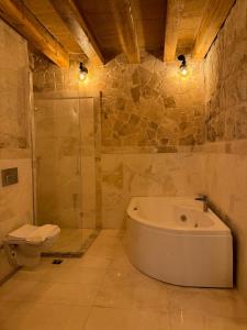 格雷梅Göreme Escape Cave Suites的带浴缸和卫生间的浴室。