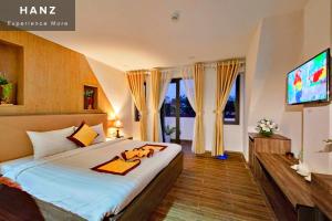 大叻HANZ Gia Hoang Hotel的一间卧室配有一张大床和电视