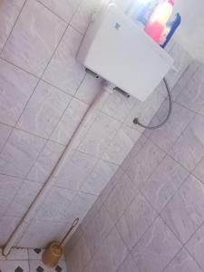 IshakaWelcominghome的白色瓷砖地板和带卫生间的浴室