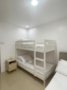 圣胡安Chan One Corner的一间卧室设有两张双层床和床头柜。