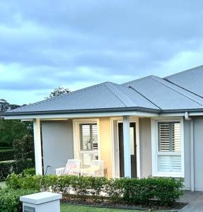 NarellanGuest house in Harrington Park的蓝色屋顶房屋,配有两把椅子