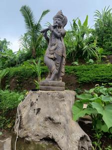 乌布BAMBOO OASIS的站在树桩顶上的女人的雕像
