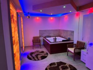 锡比乌Casa Hanea & SPA piscina exterioara incalzita ,sauna, jacuzzi privat in fiecare apartament的紫色灯的房间和带地毯的厨房