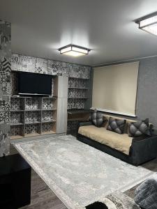 阿拉木图Ахметова 12的带沙发和平面电视的客厅
