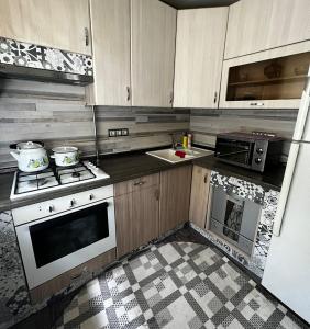 阿拉木图Ахметова 12的厨房配有木制橱柜和炉灶烤箱。