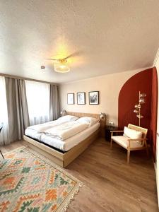 慕尼黑力士酒店的一间卧室配有一张大床和一把椅子