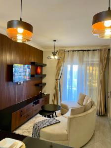 坎帕拉Athena Apartments的带沙发和电视的客厅