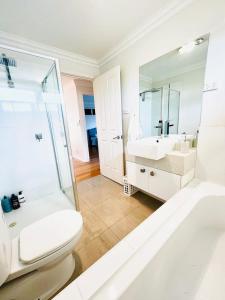 墨尔本Townhouse Near The World’s Coolest High st in 2024的白色的浴室设有卫生间和水槽。