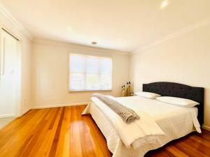 墨尔本Townhouse Near The World’s Coolest High st in 2024的一间卧室设有一张大床和一个窗户。