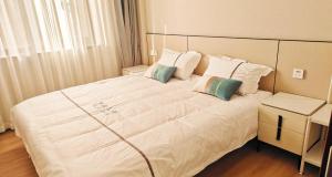 西安西安古城墙下您舒适的家的卧室配有一张带两个枕头的大白色床