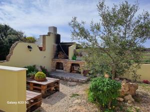 Funtana MeigaSa Cannizzada的后院设有石制壁炉和野餐桌