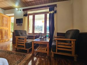 马拉里Purnima Guest House的客厅配有两把椅子和一张桌子