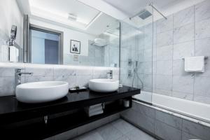 罗马玛切里诺套房旅馆的浴室设有黑色柜台上的两个盥洗盆