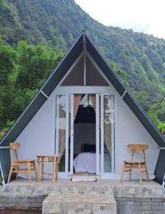 贝都古Popitan Garden Campground & Glamping Bedugul的配有一张床和两把椅子的帐篷