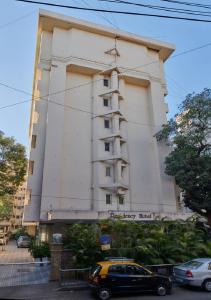 孟买Hotel Residency Andheri的前面有停车位的建筑