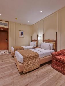 孟买Hotel Residency Andheri的酒店客房,设有两张床和一张沙发